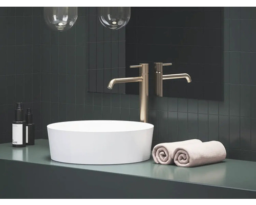 Kúpeľňa s umývadlom na dosku, batériou, uterákmi a kozmetickými produktmi