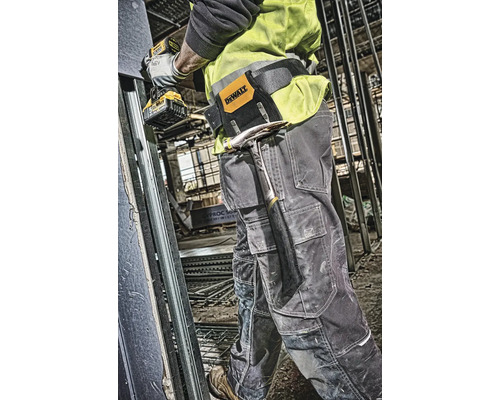 Stavebný robotník s opaskom na náradie, kladivom a akumulátorovým skrutkovačom na stavenisku