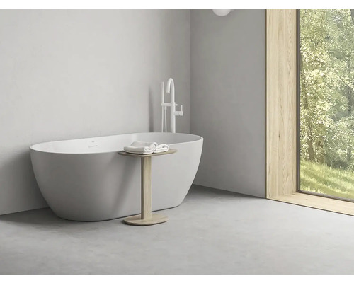 Voľne stojaca vaňa s armatúrou a príručným stolíkom v kúpeľni.