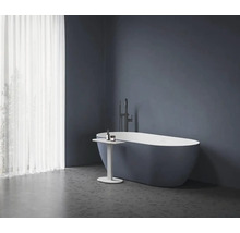 Voľne stojaca vaňa s batériou a príručným stolíkom v kúpeľni.