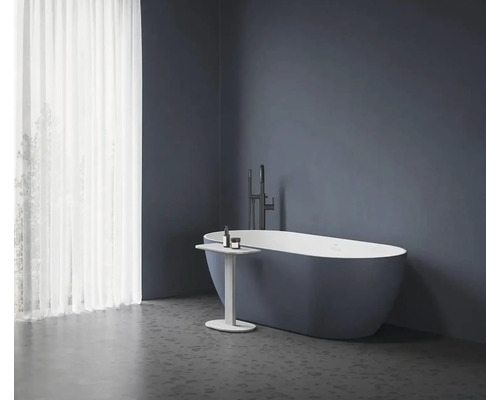 Voľne stojaca vaňa s batériou a príručným stolíkom v kúpeľni.