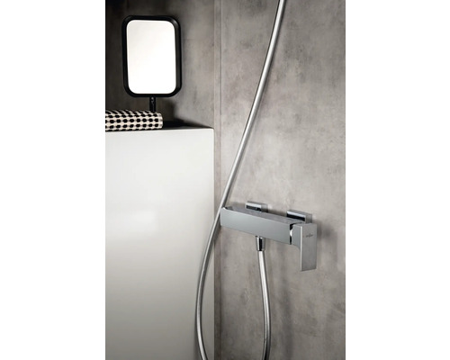 Snímka kúpeľne so sprchovou armatúrou, zrkadlom a odkladacou plochou