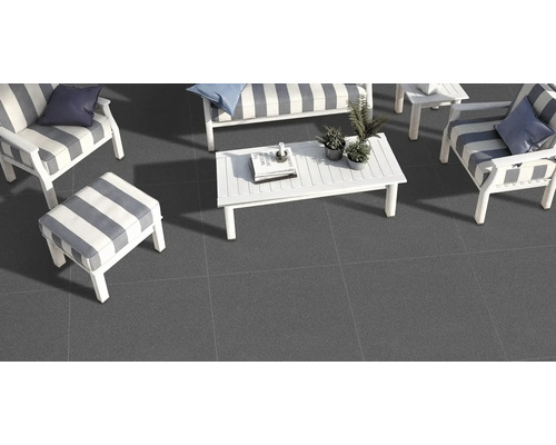 Terasa so sivou dlažbou a bielym záhradným nábytkom s pruhovanými poduškami