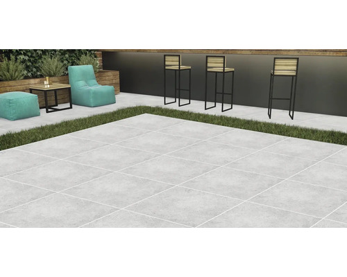 Terasa so svetlou kamennou dlažbou, doplnená o lounge nábytok a barové stoličky