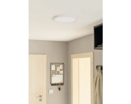 Stropné svietidlo v miestnosti s dverami, nástenkou na poznámky a vešiakom na kabáty