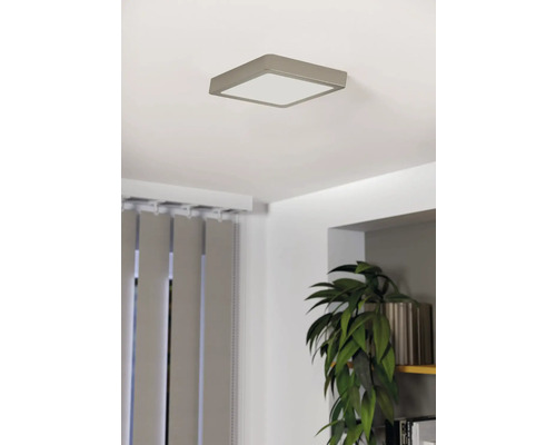 Štvorcové stropné svietidlo v svetlej miestnosti so žalúziami a črepníkovou rastlinou.