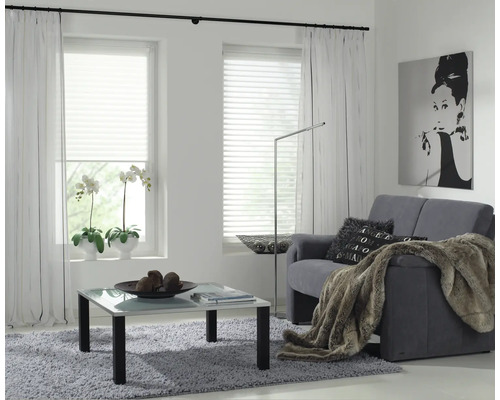 Moderná obývacia izba s pohovkou, konferenčným stolíkom, závesmi a žalúziami pre štýlové prostredie