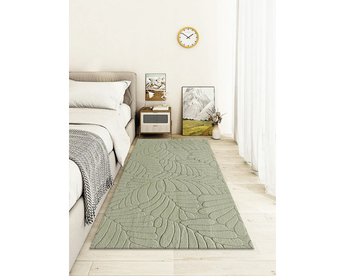 Spálňa s posteľou, nočným stolíkom a kobercom s motívom listov