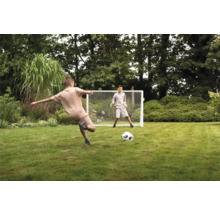 Dvaja chlapci hrajú s futbalovou bránkou v záhrade.