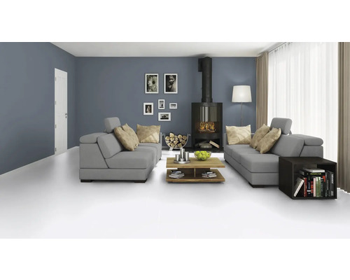 Obývacia izba so sivou sedacou súpravou, krbom, dreveným stolom a dekoráciami pre útulnú atmosféru.