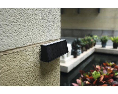 Nástenné svietidlo so solárnym panelom na stene domu