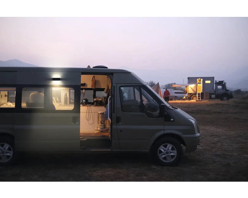 Kemping s obytnými vozidlami za súmraku