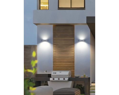 Vonkajší priestor s grilom, nástennými svietidlami a drevenými prvkami.