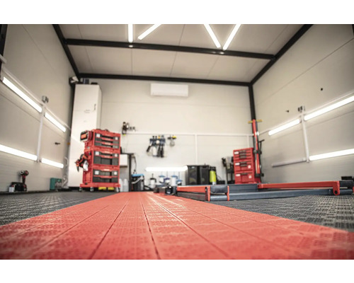 Dielňa s vozíkmi na náradie, vybavením a podlahovými krytinami.