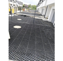Scéna s položenými zatrávňovacími dlaždicami na pozemku.
