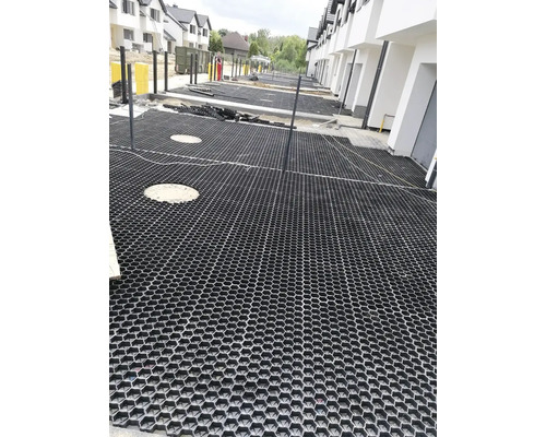 Scéna s položenými zatrávňovacími dlaždicami na pozemku.