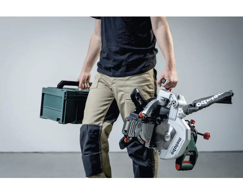 Osoba nesie pokosovú pílu Metabo a kufrík s náradím.