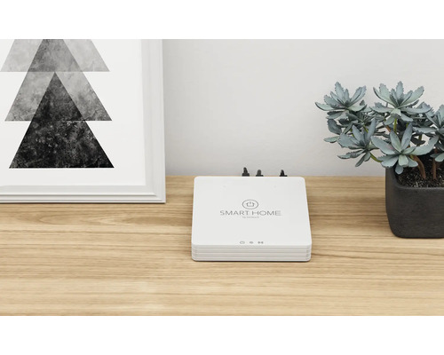 Centrála inteligentnej domácnosti na stole s dekoráciou