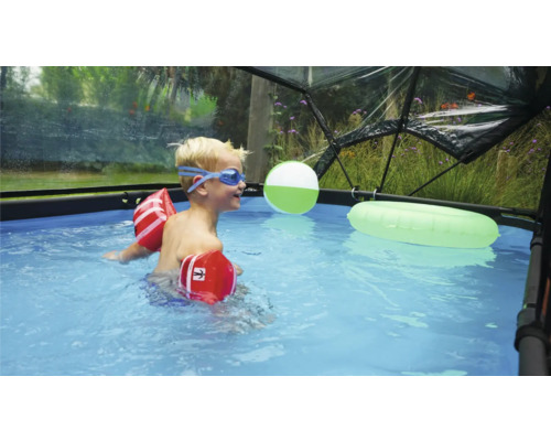 Dieťa s plávacími rukávmi a plaveckými okuliarmi v bazéne pod bazénovou kupolou