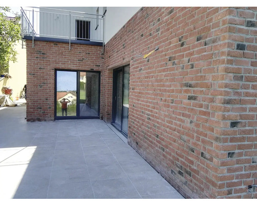 Vonkajší pohľad na dom s tehlovou stenou a posuvnými dverami