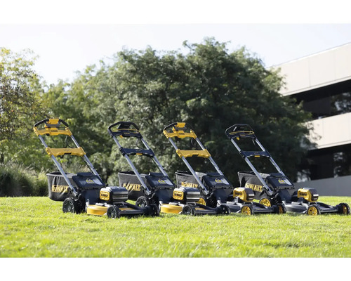 Niekoľko kosačiek na trávu DeWalt stojí na trávniku.