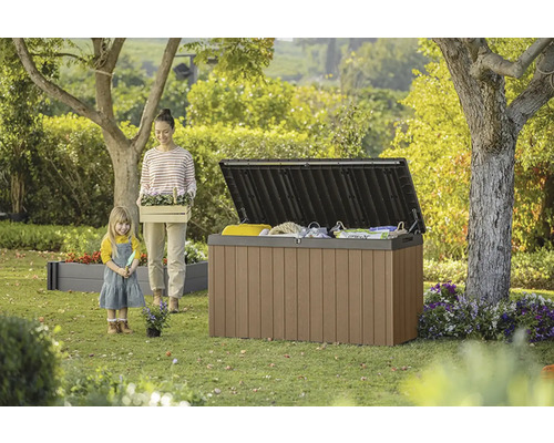 Záhradná scéna s otvoreným úložným boxom, ženou a dieťaťom.