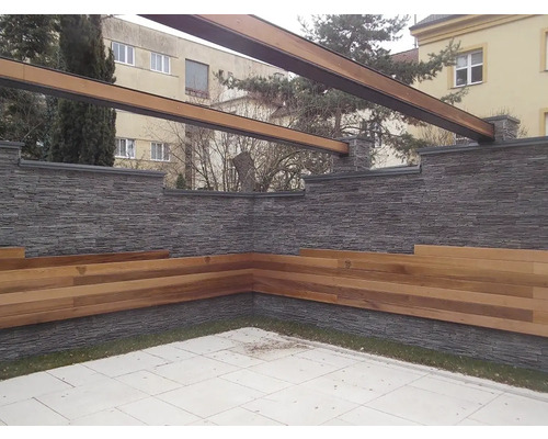 Vonkajší priestor s kamennou stenou, drevenými lavicami a pergolou