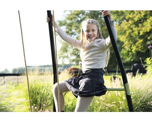 Dievča lezie na záhradnú hojdačku pre deti