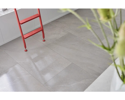 Svetlá miestnosť s podlahovými dlaždicami so vzhľadom kameňa a červeným rebríkom