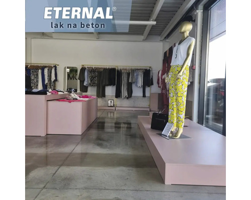 Interiérový pohľad na obchod s odevmi s oblečením na vešiakoch, prezentačnými plochami a figurínou s topom a nohavicami na leštenej betónovej podlahe.