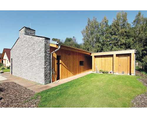 Moderný záhradný domček s dreveným obkladom, kamenným komínom a trávnikom