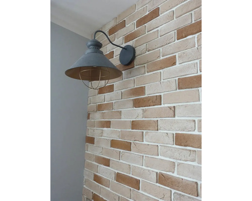 Nástenné svietidlo s klietkou na tehlovej stene