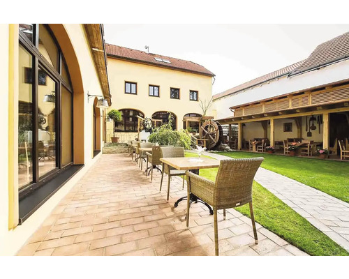 Vonkajší priestor reštaurácie so stolmi, stoličkami, terasou a trávnikom