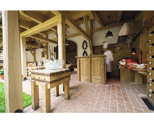 Scéna reštaurácie s drevenou konštrukciou, stolmi, stoličkami, tehlovou podlahou a barom.