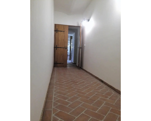 Chodba s tehlovou podlahou v tvare rybej kosti a drevenými dverami