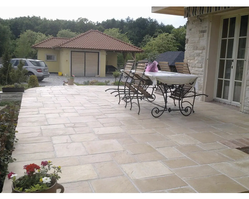 Vonkajší priestor s kamennými dlaždicami, záhradným stolom a stoličkami