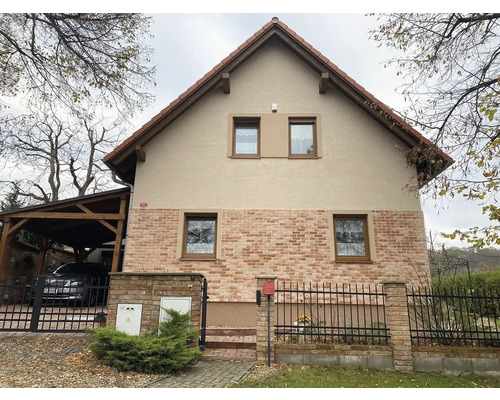 Pohľad na dvojpodlažný obytný dom s tehlovým murivom a sedlovou strechou