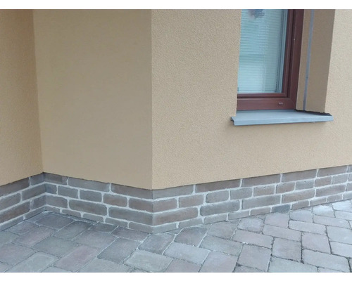 Vonkajší pohľad na dom s tehlovou pätkou a dlažobnými kockami