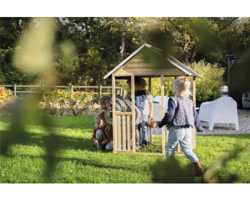 Detský drevený hrací domček s hrajúcimi sa deťmi v záhrade