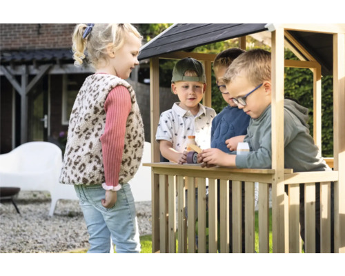 Deti sa hrajú v drevenom domčeku na záhrade.