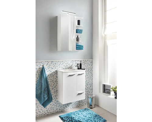 Moderná kúpeľňa s bielou skrinkou pod umývadlo, zrkadlovou skrinkou a modrou vzorovanou kúpeľňovou predložkou