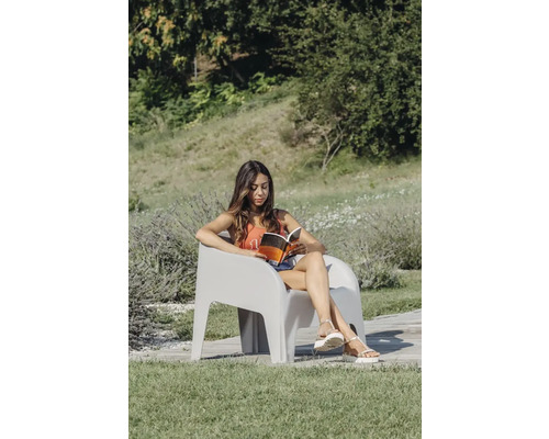 Žena číta knihu v záhradnom kresle