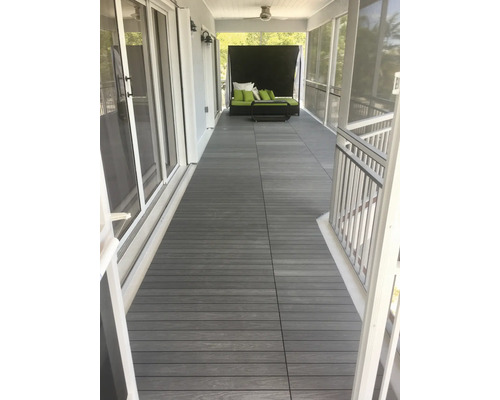 Veranda s terasovými doskami z drevoplastu a záhradným nábytkom.