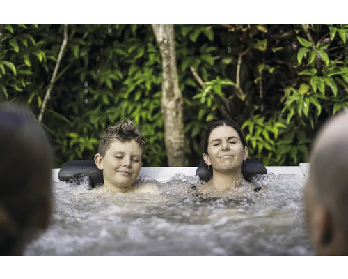 Uvoľnená rodina si užíva teplú vírivku v záhrade