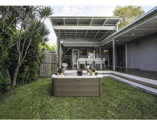 Scéna s vírivkou v záhrade, v ktorej relaxuje niekoľko ľudí.