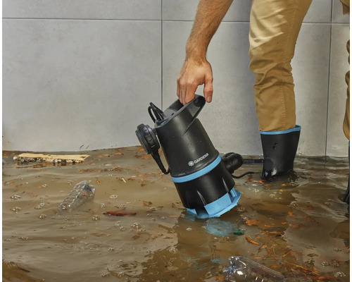 Osoba používa kalové čerpadlo Gardena v zatopenej miestnosti.