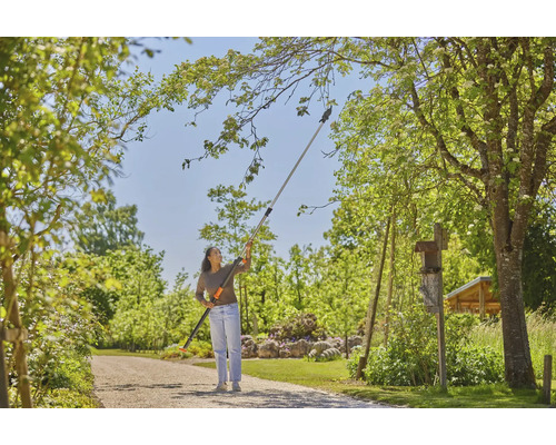 Žena používa nožnice na konáre s teleskopickou násadou v záhrade na prerezávanie konárov