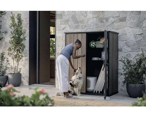 Žena so psom pred otvorenou skriňou na náradie vo vonkajšom prostredí