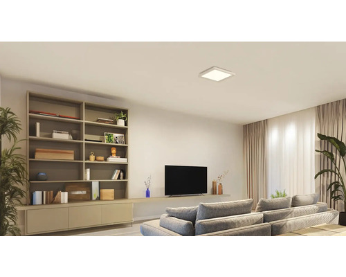 Obývacia izba s knižnicou, televízorom, pohovkou a štvorcovým stropným svietidlom