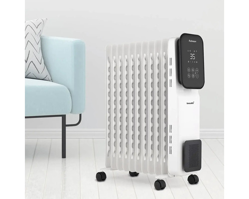 Biely olejový radiátor s digitálnym displejom a kolieskami vedľa svetlomodrého kresla